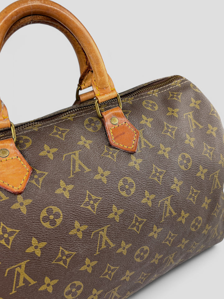 Louis Vuitton Speedy Reisetasche aus Monogramm-Canvas in Braun mit goldfarbenen Beschlägen und Lederdetails. Geräumig und stilvoll
