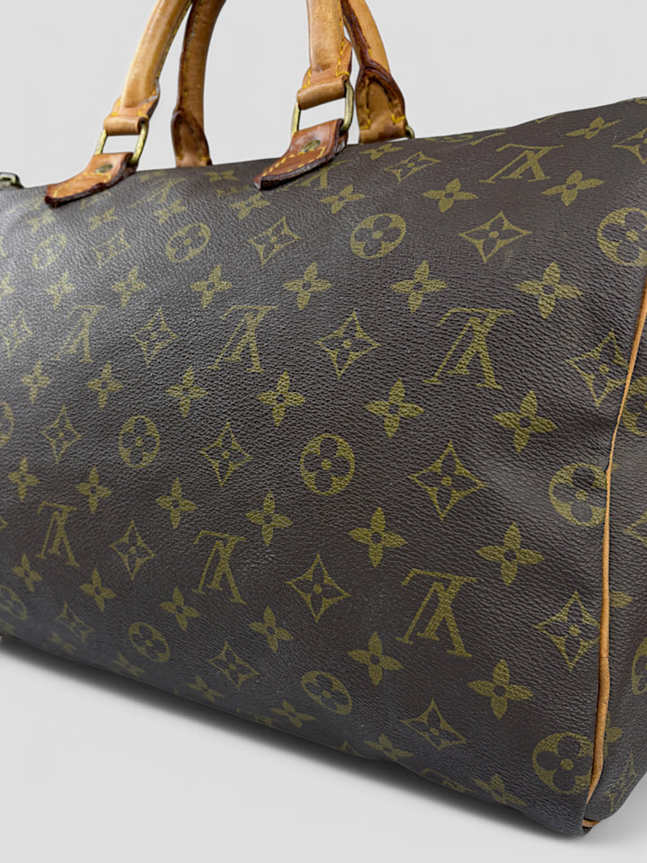 Louis Vuitton Speedy Reisetasche aus Monogramm-Canvas in Braun mit goldfarbenen Beschlägen und Lederdetails. Geräumig und stilvoll