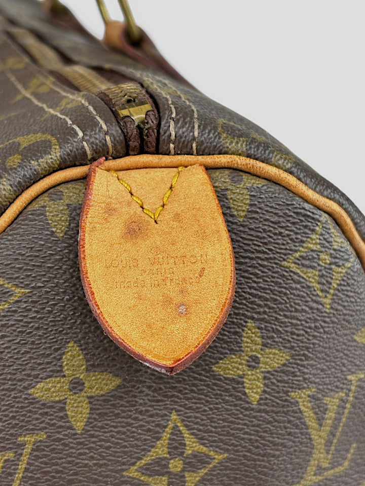 Louis Vuitton Speedy Reisetasche aus Monogramm-Canvas in Braun mit goldfarbenen Beschlägen und Lederdetails. Geräumig und stilvoll
