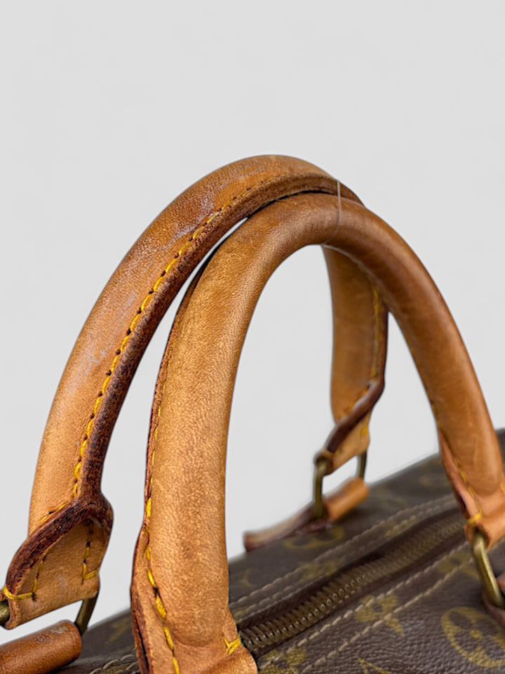 Louis Vuitton Speedy Reisetasche aus Monogramm-Canvas in Braun mit goldfarbenen Beschlägen und Lederdetails. Geräumig und stilvoll
