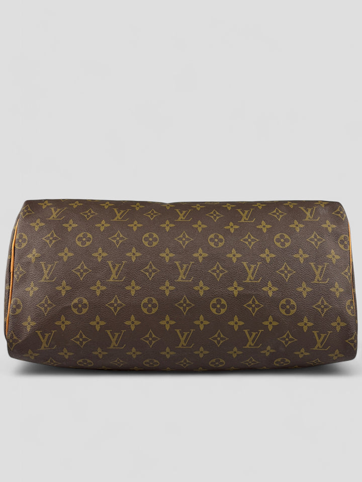 Louis Vuitton Speedy Reisetasche aus Monogramm-Canvas in Braun mit goldfarbenen Beschlägen und Lederdetails. Geräumig und stilvoll