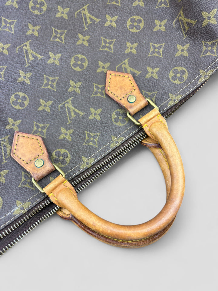 Louis Vuitton Speedy Reisetasche aus Monogramm-Canvas in Braun mit goldfarbenen Beschlägen und Lederdetails. Geräumig und stilvoll