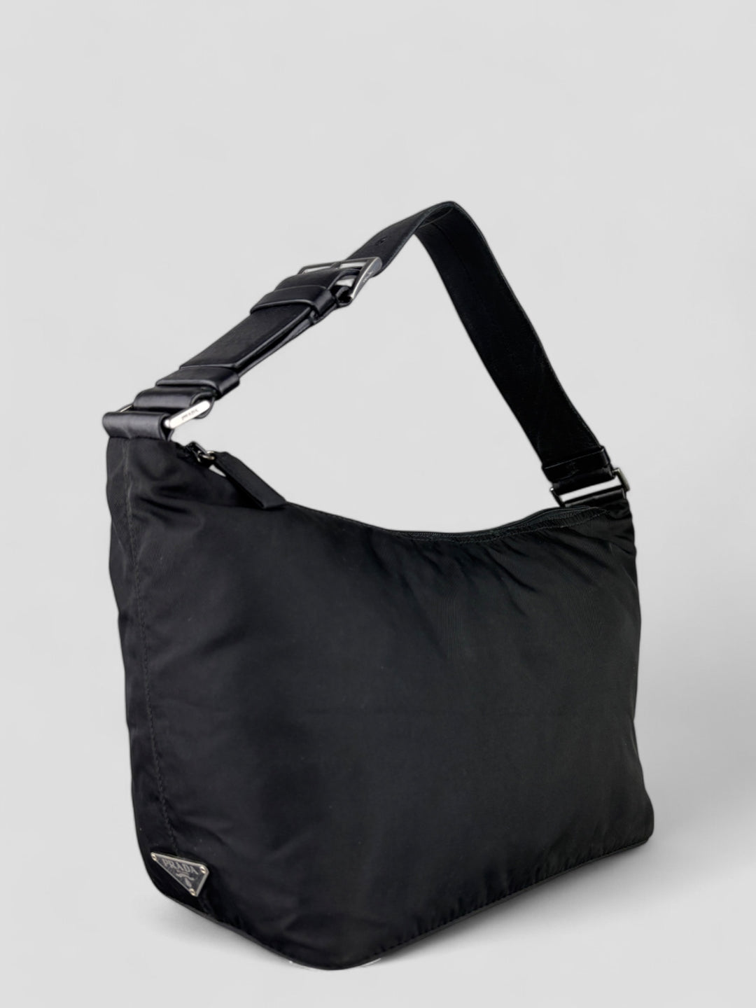 Prada Banana Schultertasche aus schwarzem Nylon mit verstellbarem Schulterriemen und klassischem Prada-Dreiecks-Logoaufnäher. Schlicht, praktisch und elegant