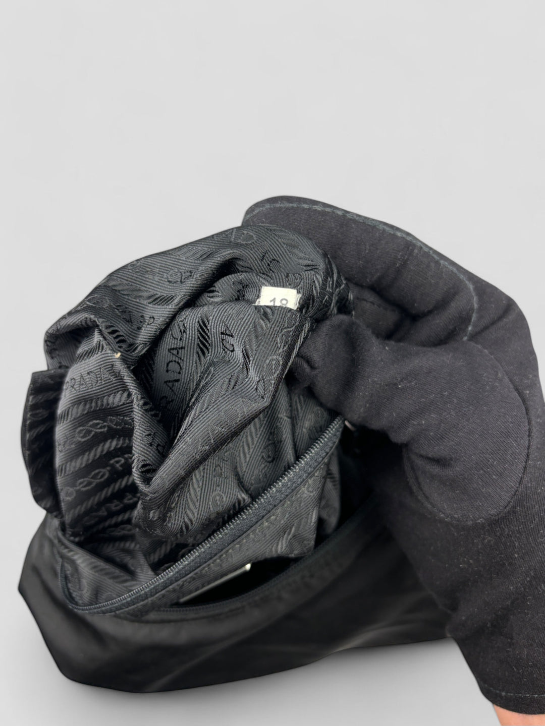 Prada Banana Schultertasche aus schwarzem Nylon mit verstellbarem Schulterriemen und klassischem Prada-Dreiecks-Logoaufnäher. Schlicht, praktisch und elegant