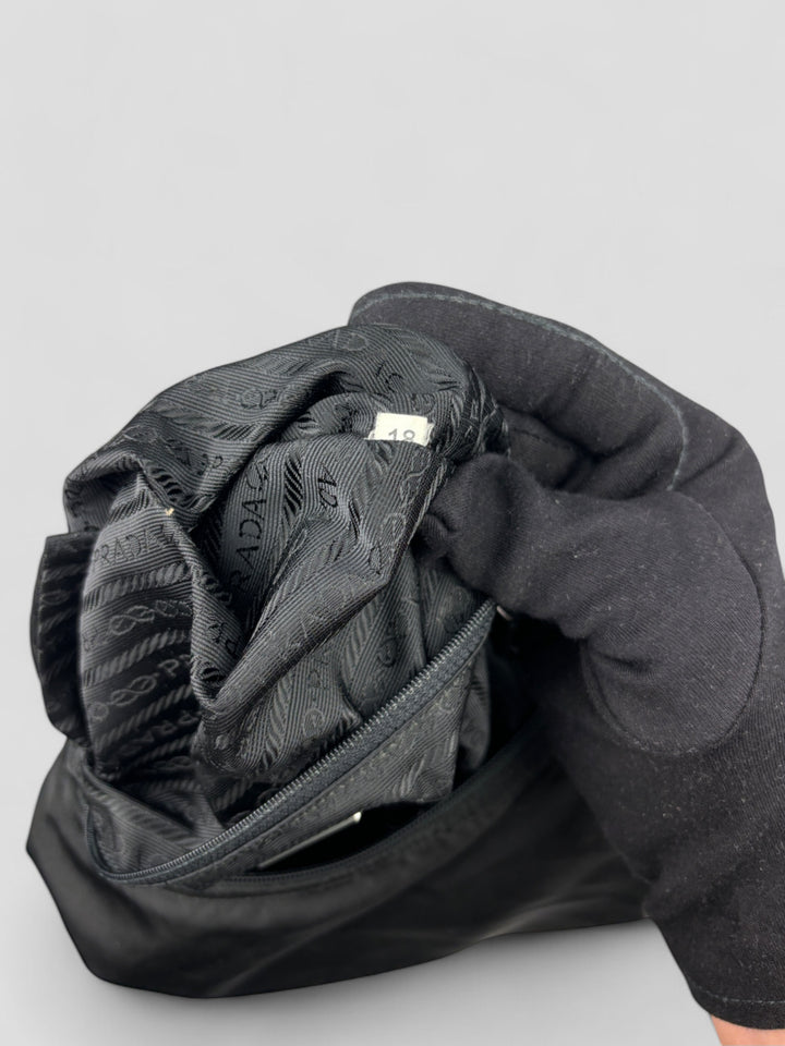 Prada Banana Schultertasche aus schwarzem Nylon mit verstellbarem Schulterriemen und klassischem Prada-Dreiecks-Logoaufnäher. Schlicht, praktisch und elegant