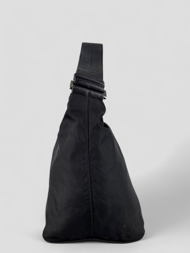 Prada Banana Schultertasche aus schwarzem Nylon mit verstellbarem Schulterriemen und klassischem Prada-Dreiecks-Logoaufnäher. Schlicht, praktisch und elegant
