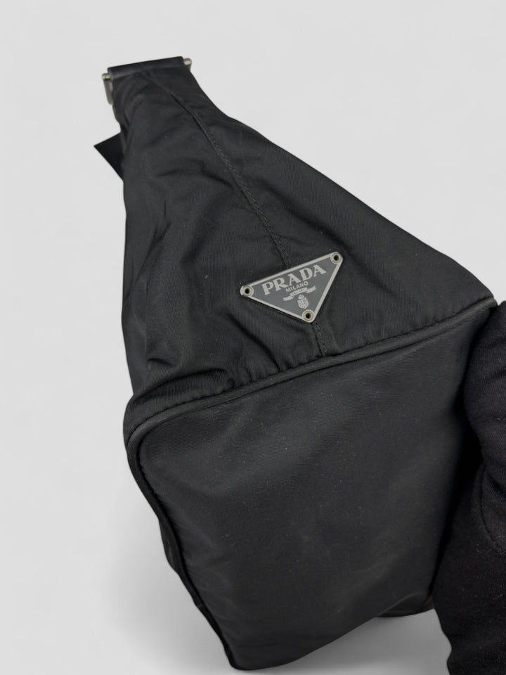 Prada Banana Schultertasche aus schwarzem Nylon mit verstellbarem Schulterriemen und klassischem Prada-Dreiecks-Logoaufnäher. Schlicht, praktisch und elegant