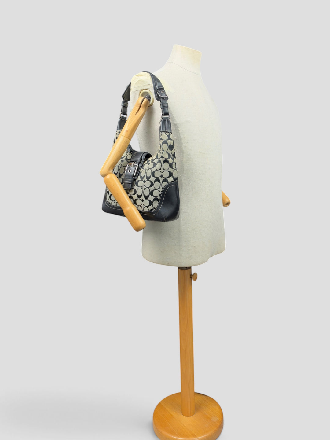 Coach Signature Soho Buckle Hobo Shoulder Bag in Grau/Schwarz, getragen an der Schneiderpuppe