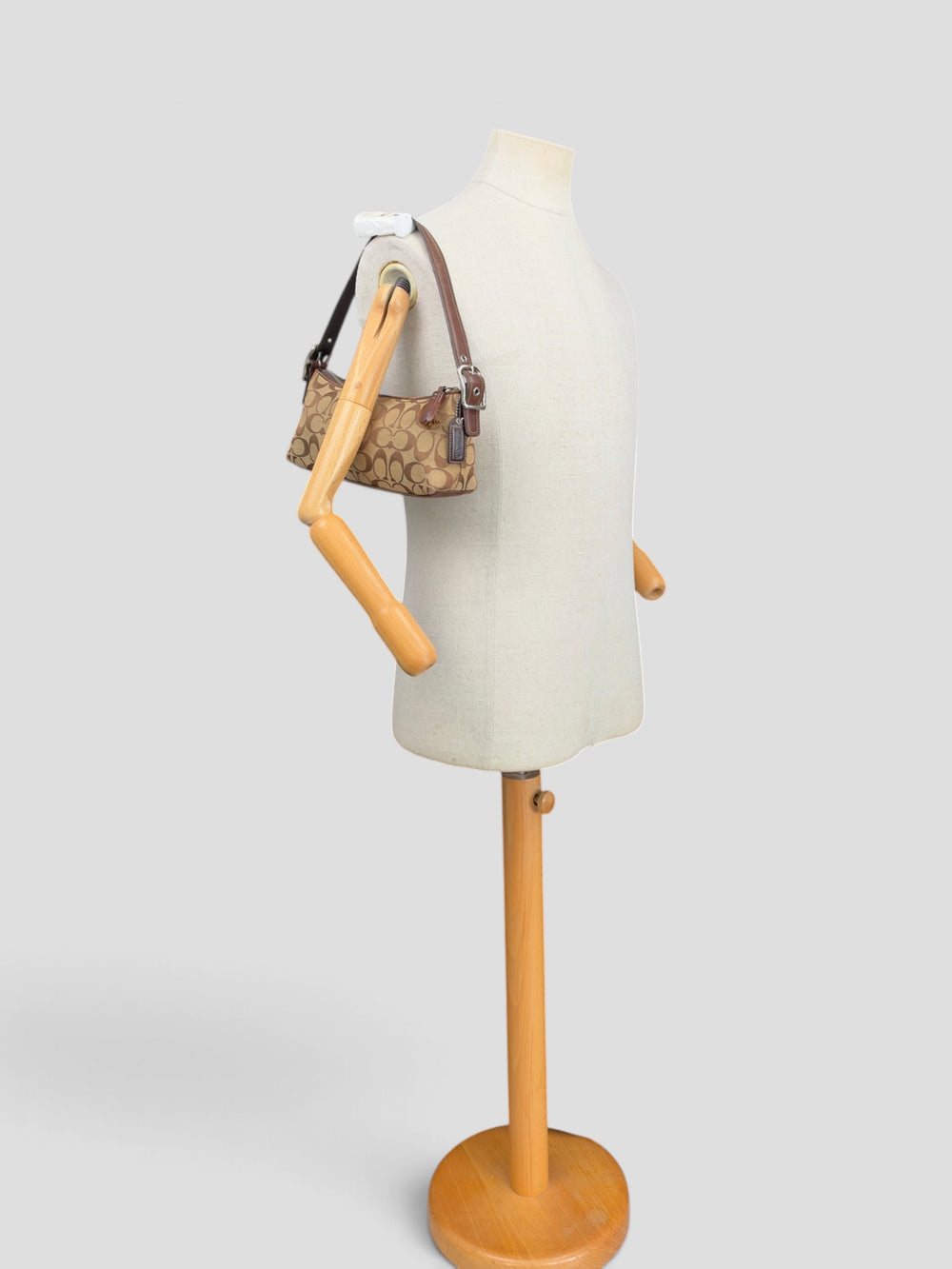 Coach Signature Suede Stripe Baguette Shoulder Bag in Khaki/Braun, getragen an der Schneiderpuppe