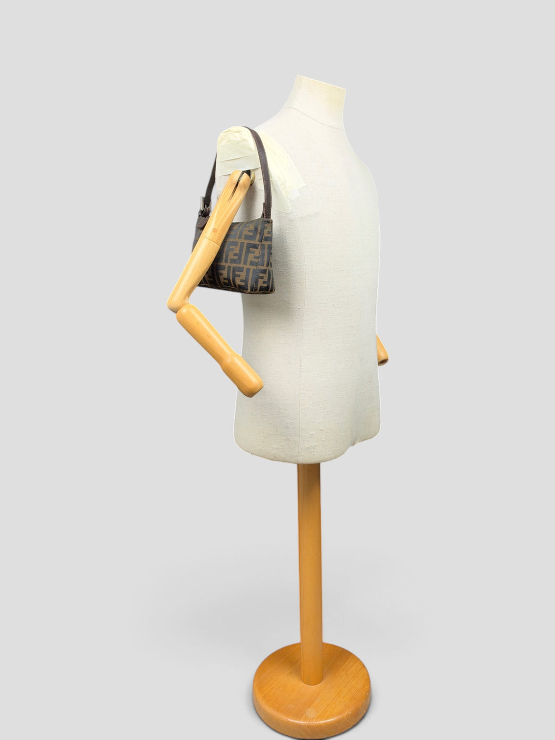 Fendi Zucca Canvas Baguette Pochette Shoulder Bag in Tabak/Schwarz, getragen an der Schneiderpuppe